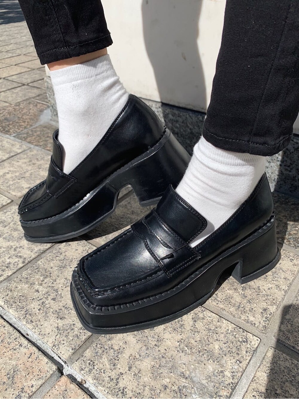 ブラック系のデニムパンツ、ブラック系のローファー、ブラック系のショルダーバッグを着用したレディースの春コーディネートの9枚目の写真