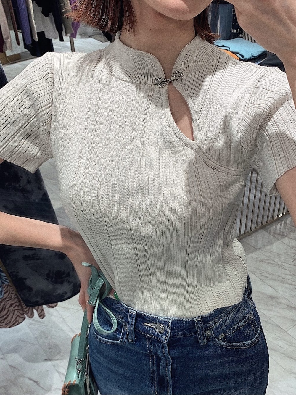 ホワイト系のニット/セーター、ブラック系のブーツ、ブルー系のデニムパンツを着用したレディースの冬コーディネートの3枚目の写真