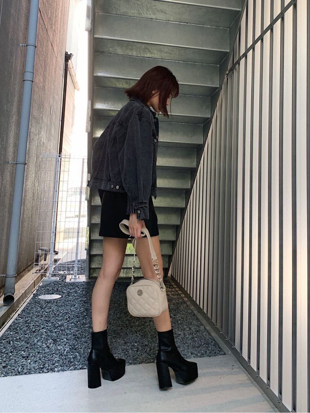 グレー系のTシャツ/カットソー、ブラック系のブーツ、ホワイト系のショルダーバッグを着用したレディースの秋コーディネートの2枚目の写真