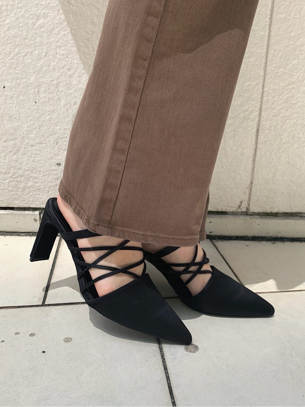 ブラウン系のデニムパンツ、ホワイト系のキャミソール、ブラック系のサンダルを着用したレディースの秋コーディネートの6枚目の写真