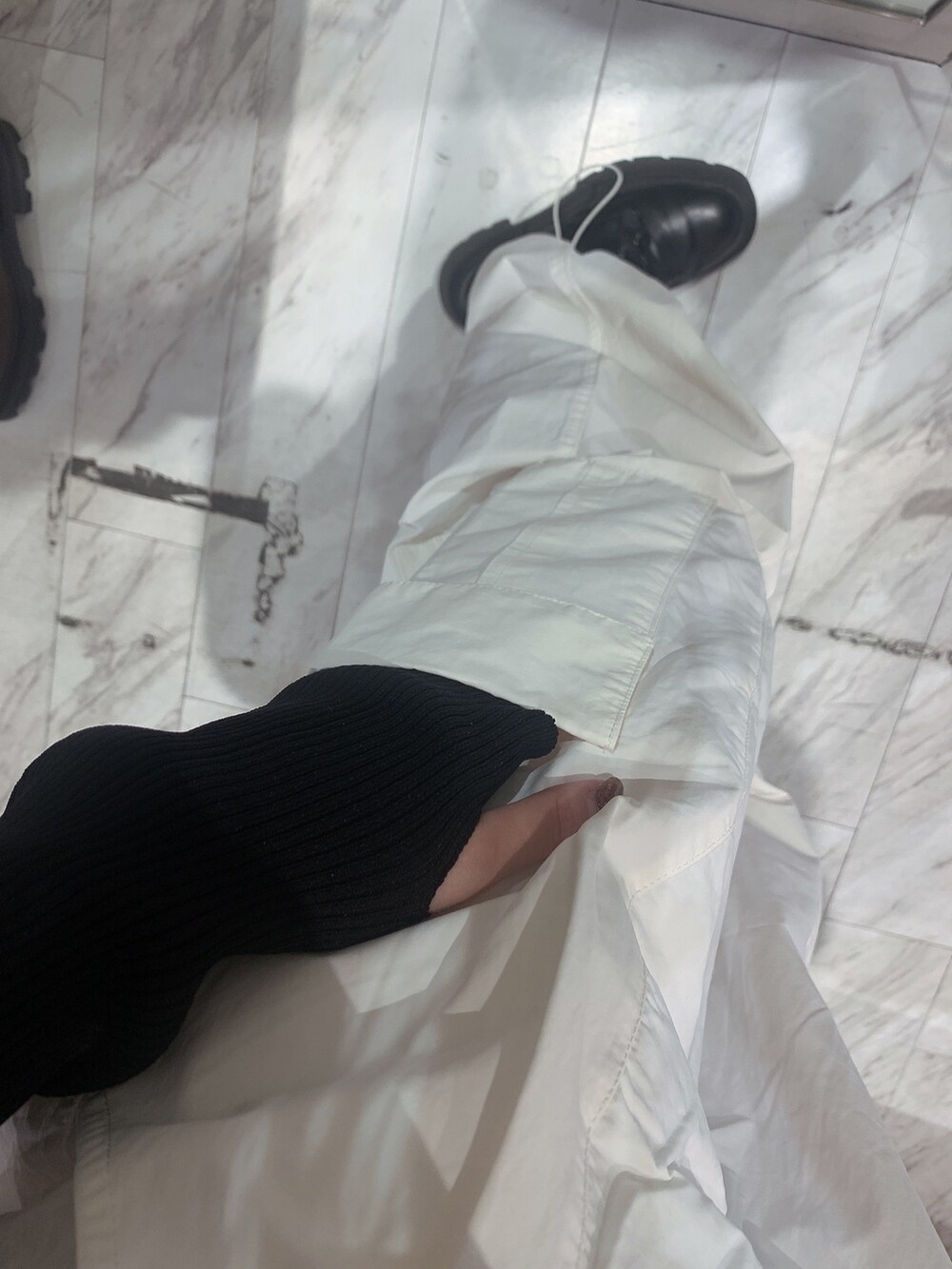 ホワイト系のカーゴパンツ、ブラック系のニット/セーター、グリーン系のショルダーバッグを着用したレディースの春コーディネートの8枚目の写真