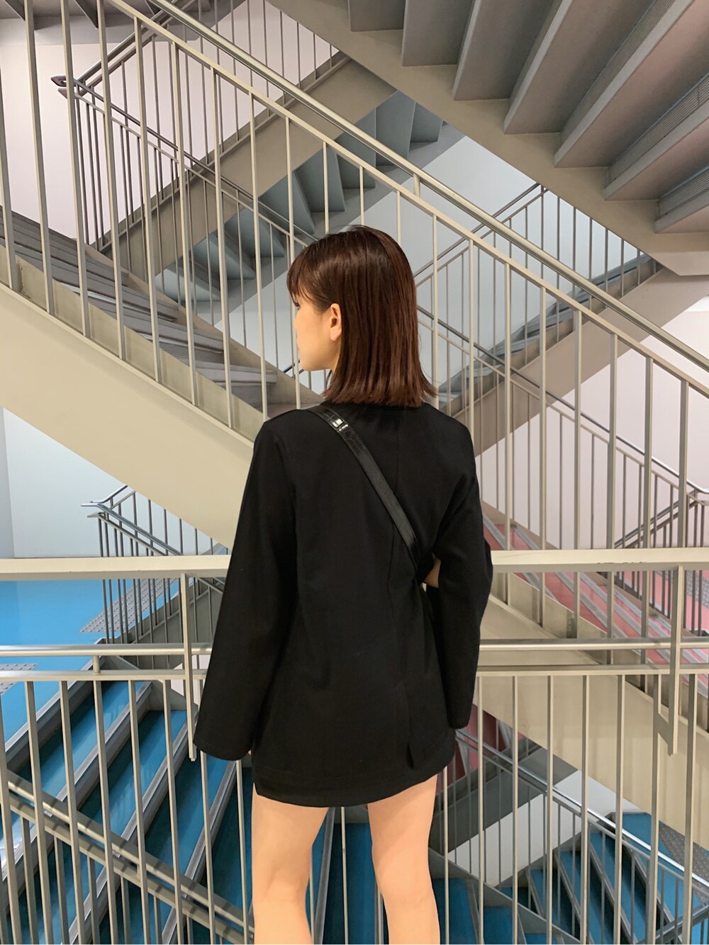 グレー系のテーラードジャケット、ブラック系のTシャツ/カットソー、ブラック系のスカートを着用したレディースの冬コーディネートの3枚目の写真