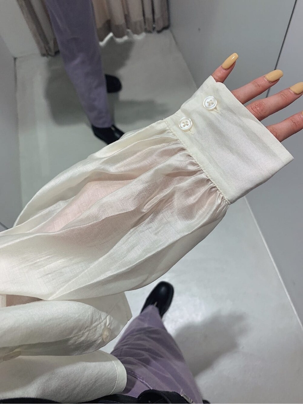 ブラック系のブーツ、ブラック系のキャミソール、パープル系のデニムパンツを着用したレディースの春コーディネートの4枚目の写真