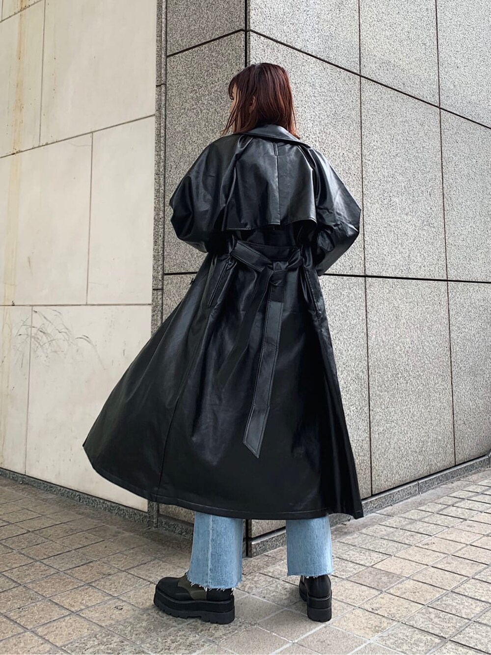 ホワイト系のニット/セーター、ベージュ系のブーツ、ブラック系のトレンチコートを着用したレディースの冬コーディネートの3枚目の写真