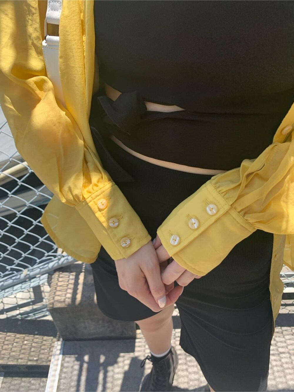 ブラック系のTシャツ/カットソー、ホワイト系のショルダーバッグ、ブラック系のその他パンツを着用したレディースの夏コーディネートの6枚目の写真