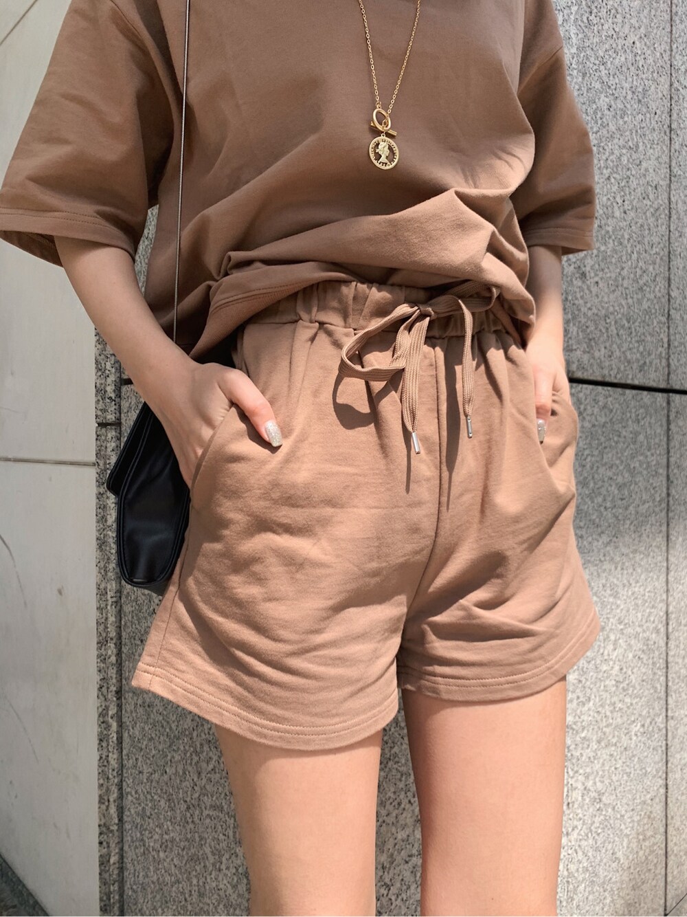 ブラウン系のスウェットを着用したレディースの春コーディネートの2枚目の写真