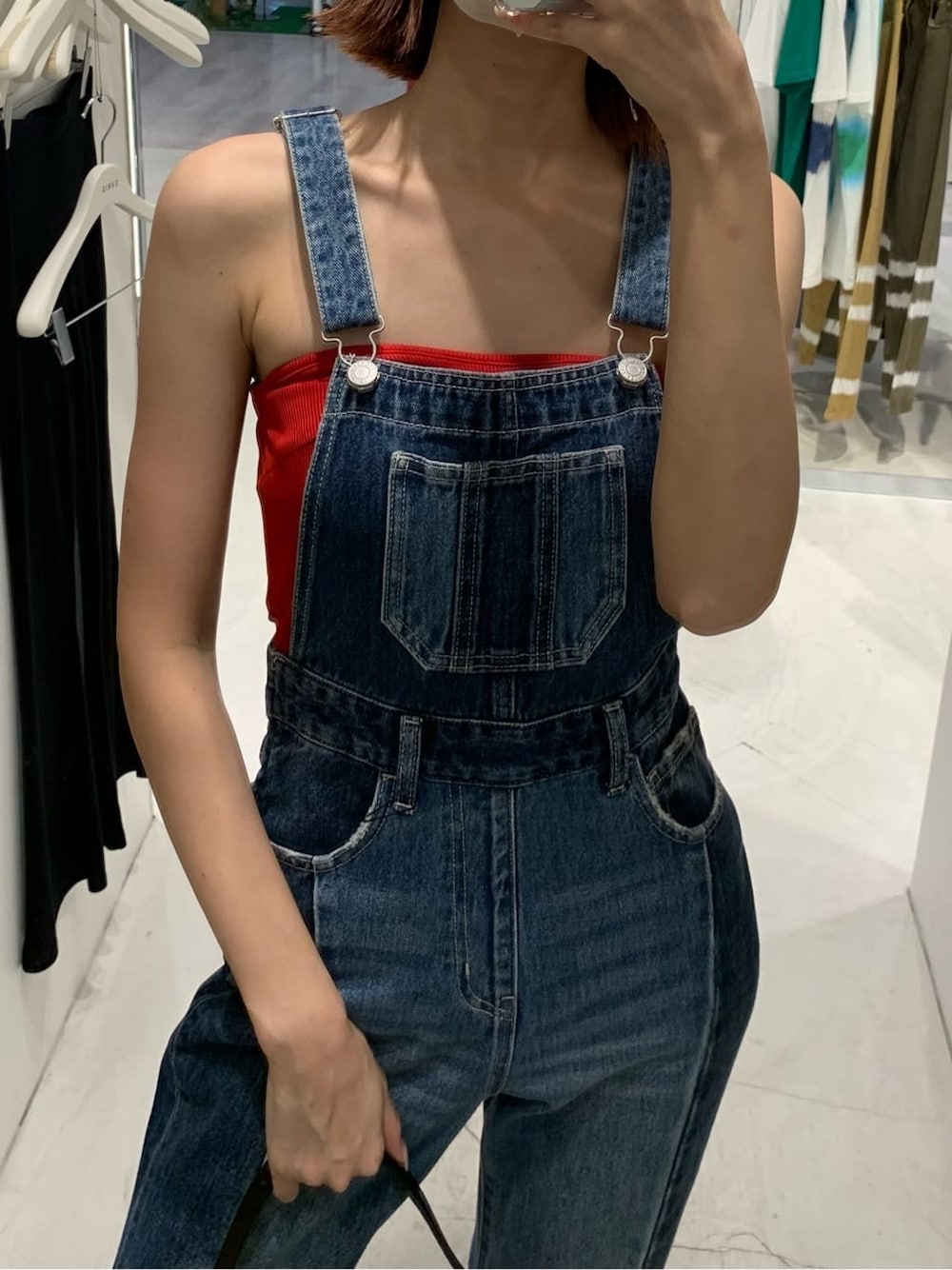 ブルー系のサロペット/オーバーオール、ブラック系のショルダーバッグ、ホワイト系のサンダルを着用したレディースの夏コーディネートの2枚目の写真