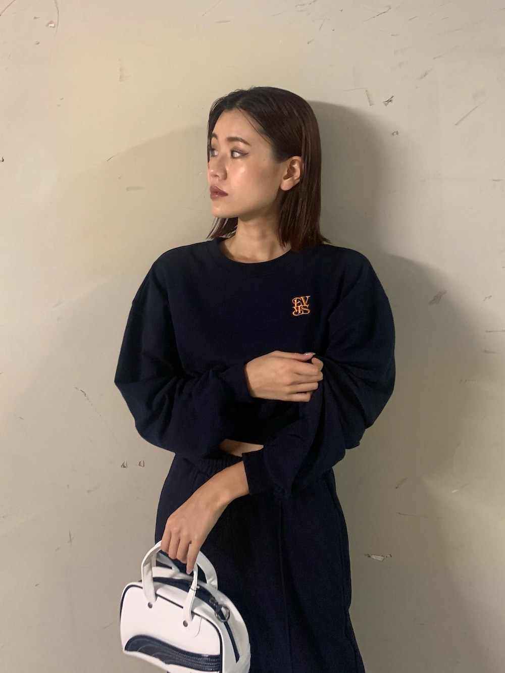 ブルー系のスウェット、ブルー系のスウェットパンツ、ホワイト系のハンドバッグを着用したレディースの秋コーディネートの4枚目の写真