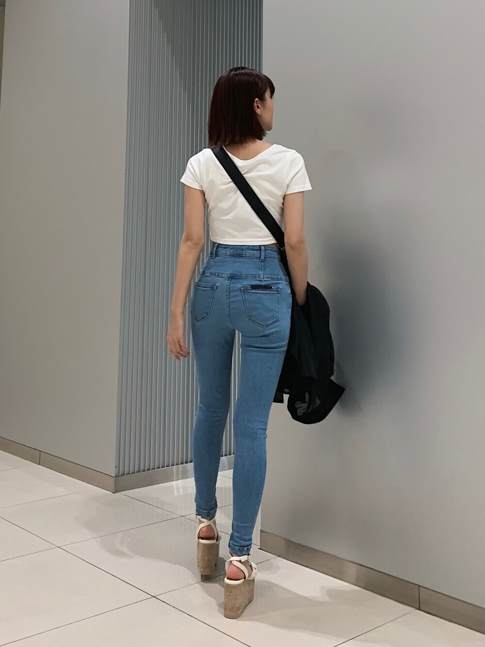 ブルー系のデニムパンツ、ブラック系のシャツ/ブラウス、ホワイト系のTシャツ/カットソーを着用したレディースの春コーディネートの4枚目の写真