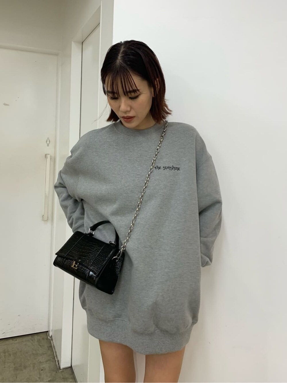 ブラック系のブーツ、グレー系のスウェット、ブラック系のブルゾンを着用したレディースの秋コーディネートの3枚目の写真