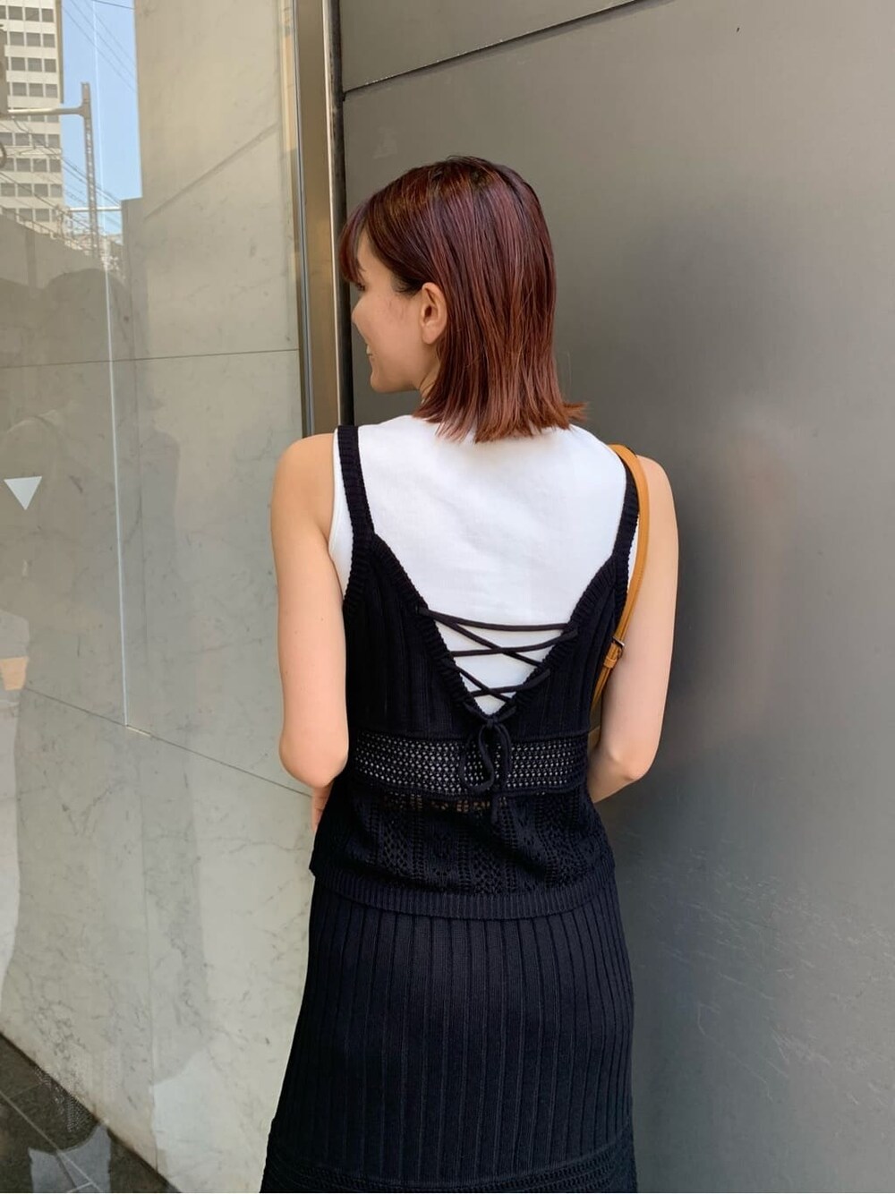 ホワイト系のタンクトップ、ブラック系のキャミソール、ベージュ系のショルダーバッグを着用したレディースの夏コーディネートの5枚目の写真