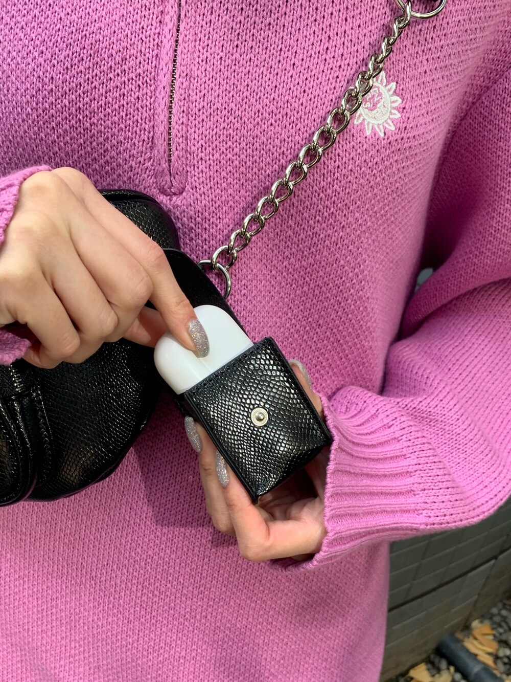 ピンク系のニット/セーター、ブラック系のブーツ、ブラック系のボディバッグ/ウエストポーチを着用したレディースの冬コーディネートの6枚目の写真