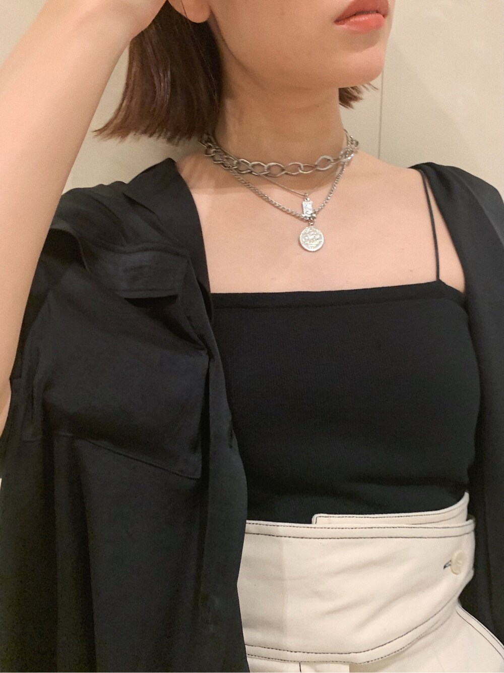 ホワイト系のスカート、ブラック系のサンダル、ブラック系のシャツ/ブラウスを着用したレディースの春コーディネートの9枚目の写真