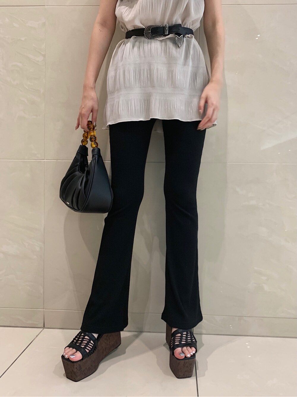 ホワイト系のTシャツ/カットソー、ブラック系のその他パンツ、ブラック系のハンドバッグを着用したレディースの春コーディネートの6枚目の写真