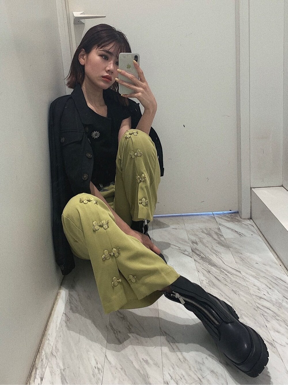 ブラック系のブーツ、ブラック系のブルゾン、グリーン系のその他パンツを着用したレディースの春コーディネートの9枚目の写真