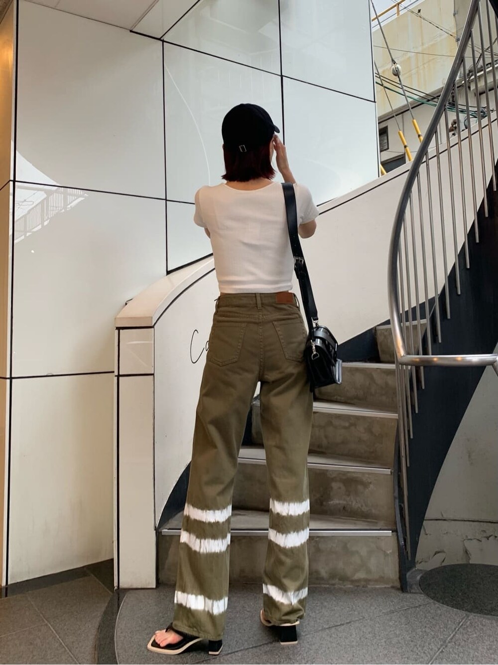 ホワイト系のTシャツ/カットソー、ブラック系のサンダル、ブラック系のショルダーバッグを着用したレディースの夏コーディネートの3枚目の写真