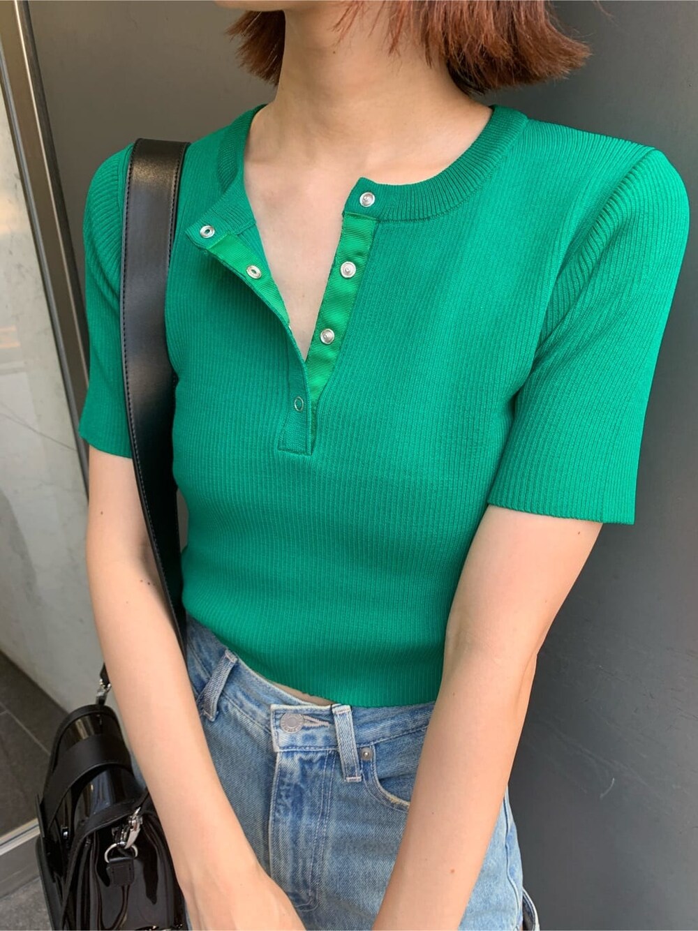 ブルー系のデニムパンツ、ブラック系のサンダル、ブラック系のショルダーバッグを着用したレディースの夏コーディネートの4枚目の写真