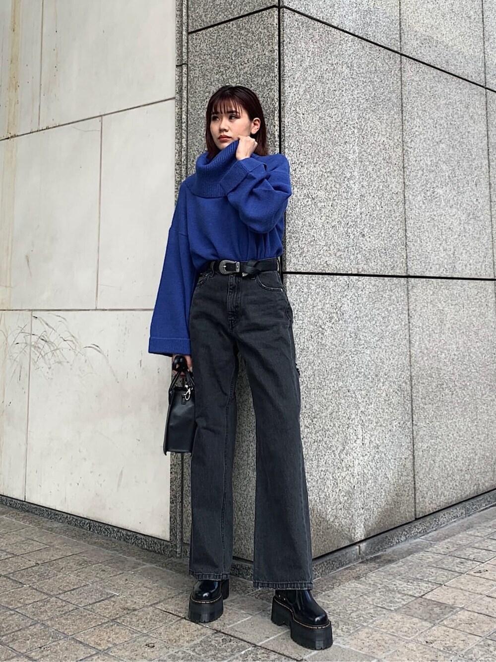 ブラック系のデニムパンツ、ブラック系のブーツ、ブラック系のショルダーバッグを着用したレディースの冬コーディネートの2枚目の写真