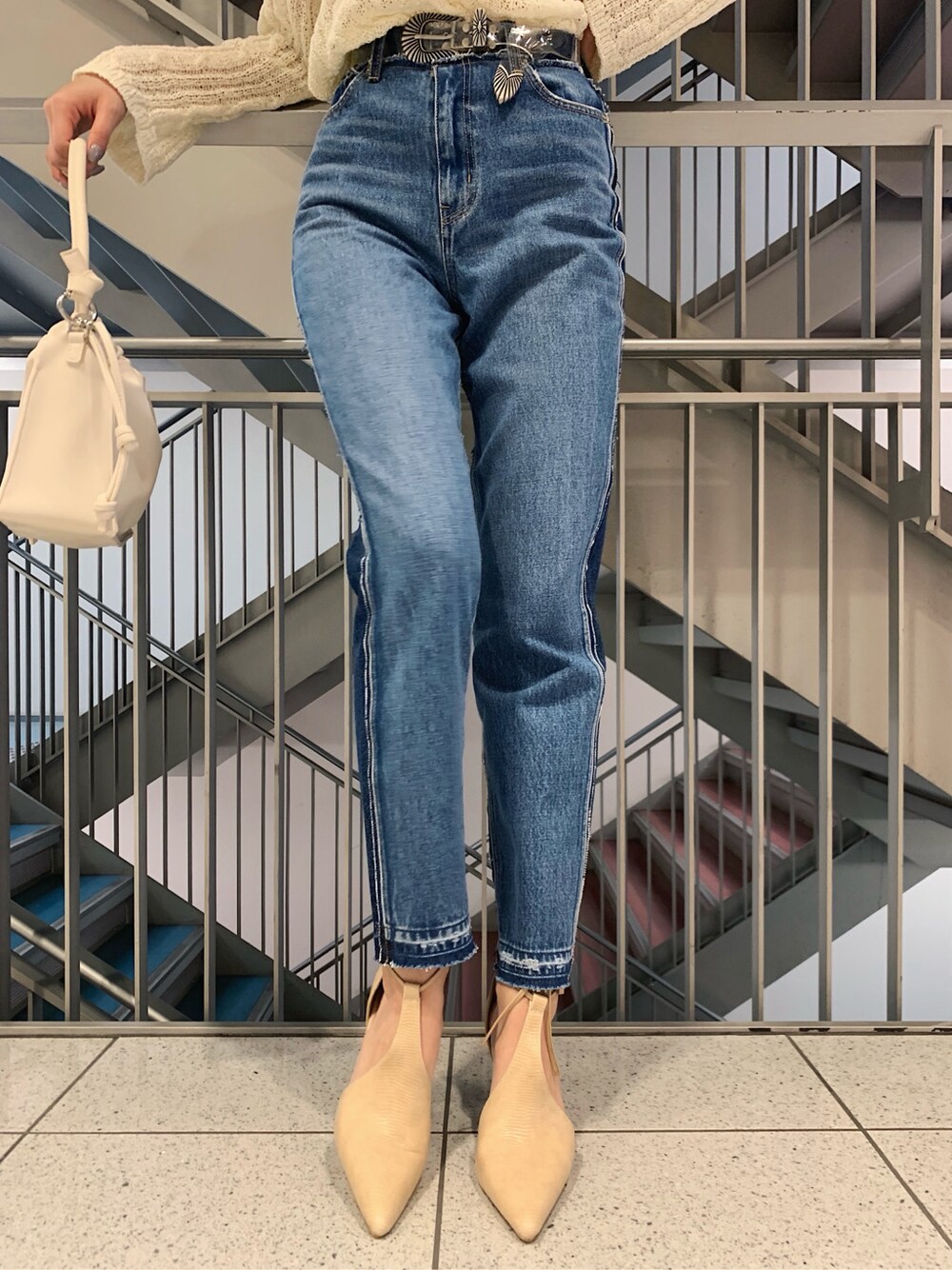 ホワイト系のニット/セーター、ベージュ系のパンプス、ホワイト系のショルダーバッグを着用したレディースの春コーディネートの5枚目の写真