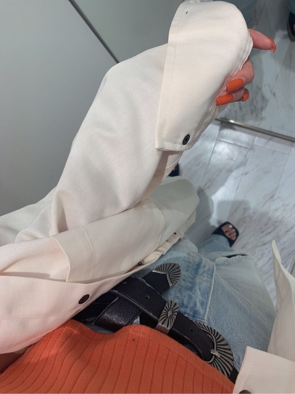 ホワイト系のシャツ/ブラウス、ブラック系のサンダル、ブルー系のデニムパンツを着用したレディースの夏コーディネートの5枚目の写真