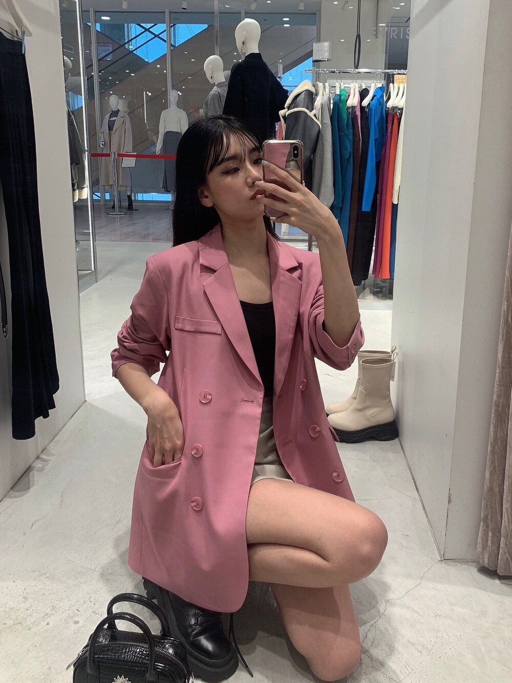 ピンク系のテーラードジャケット、ホワイト系のスカート、ブラック系のショルダーバッグを着用したレディースの冬コーディネートの10枚目の写真