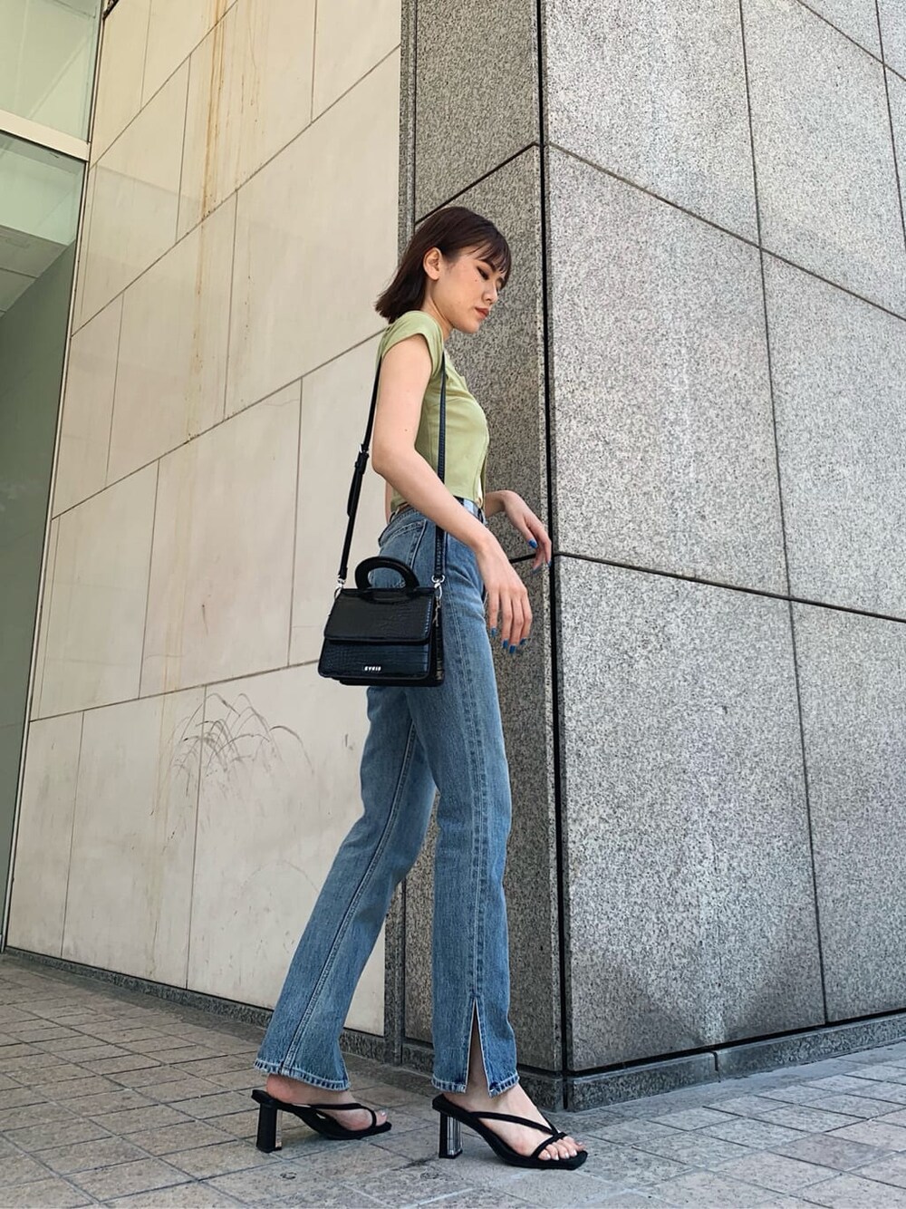 グリーン系のTシャツ/カットソー、ブルー系のデニムパンツ、ブラック系のサンダルを着用したレディースの夏コーディネートの2枚目の写真