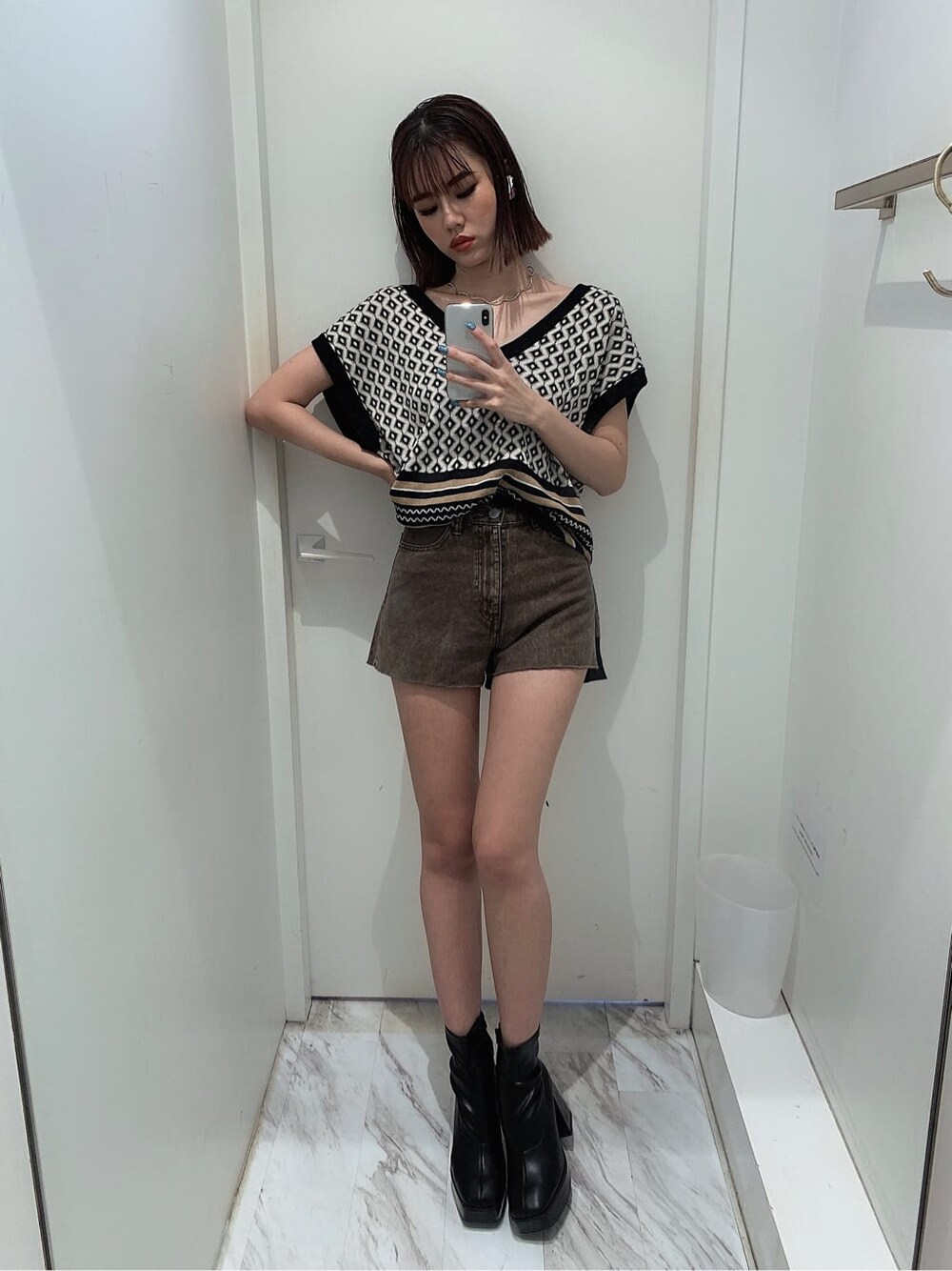 ブラウン系のデニムパンツ、ゴールド系のネックレスを着用したレディースの夏コーディネートの2枚目の写真