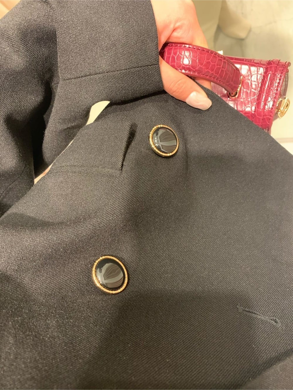 ブラック系のテーラードジャケット、ブラック系のスカート、ホワイト系のブーツを着用したレディースの秋コーディネートの5枚目の写真