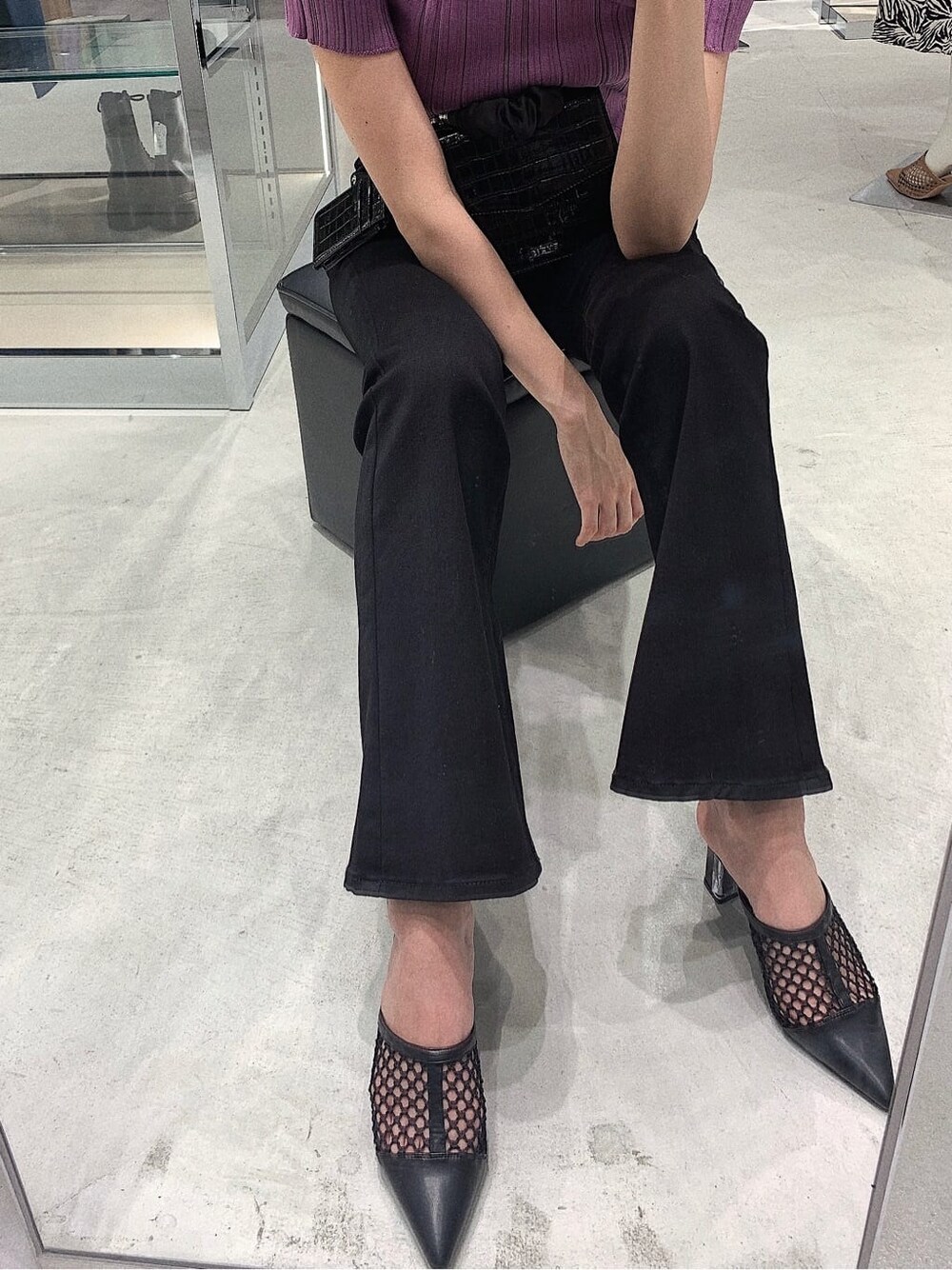 ブラック系のパンプス、ブラック系のデニムパンツ、パープル系のニット/セーターを着用したレディースの春コーディネートの6枚目の写真