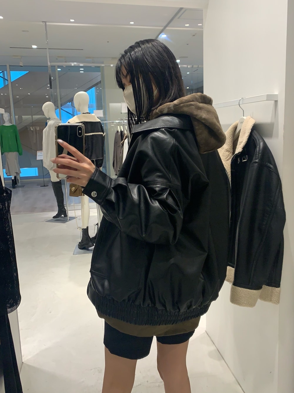 ブラック系のブーツ、ブラック系のハンドバッグ、ブラック系のブルゾンを着用したレディースの秋コーディネートの3枚目の写真