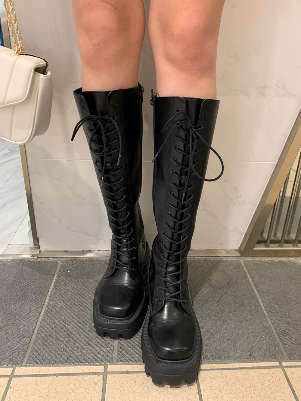 レッド系のニット/セーター、ブラック系のムートンコート、ブラック系のその他パンツを着用したレディースの夏コーディネートの8枚目の写真