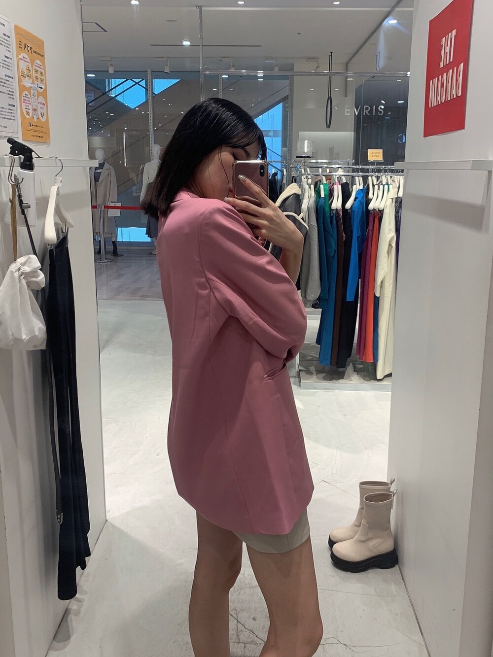 ピンク系のテーラードジャケット、ホワイト系のスカート、ブラック系のショルダーバッグを着用したレディースの冬コーディネートの6枚目の写真