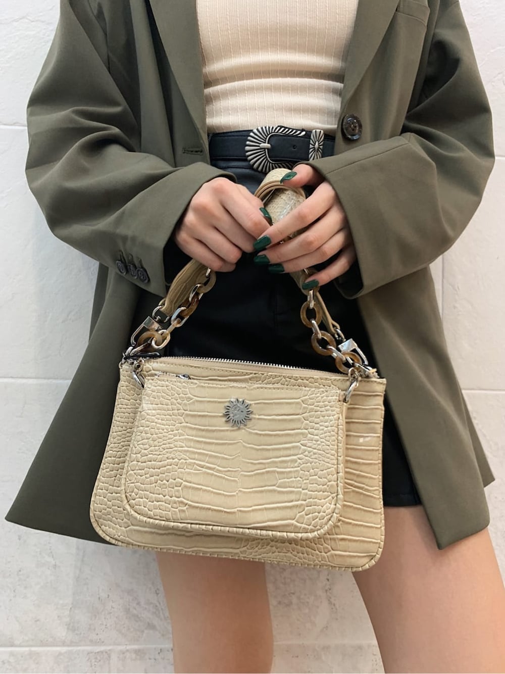 ホワイト系のキャミソール、ベージュ系のテーラードジャケット、ブラック系のブーツを着用したレディースの秋コーディネートの6枚目の写真