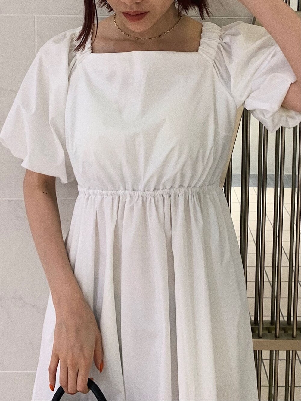 ホワイト系のワンピース、ブラック系のショルダーバッグ、その他のサンダルを着用したレディースの春コーディネートの3枚目の写真