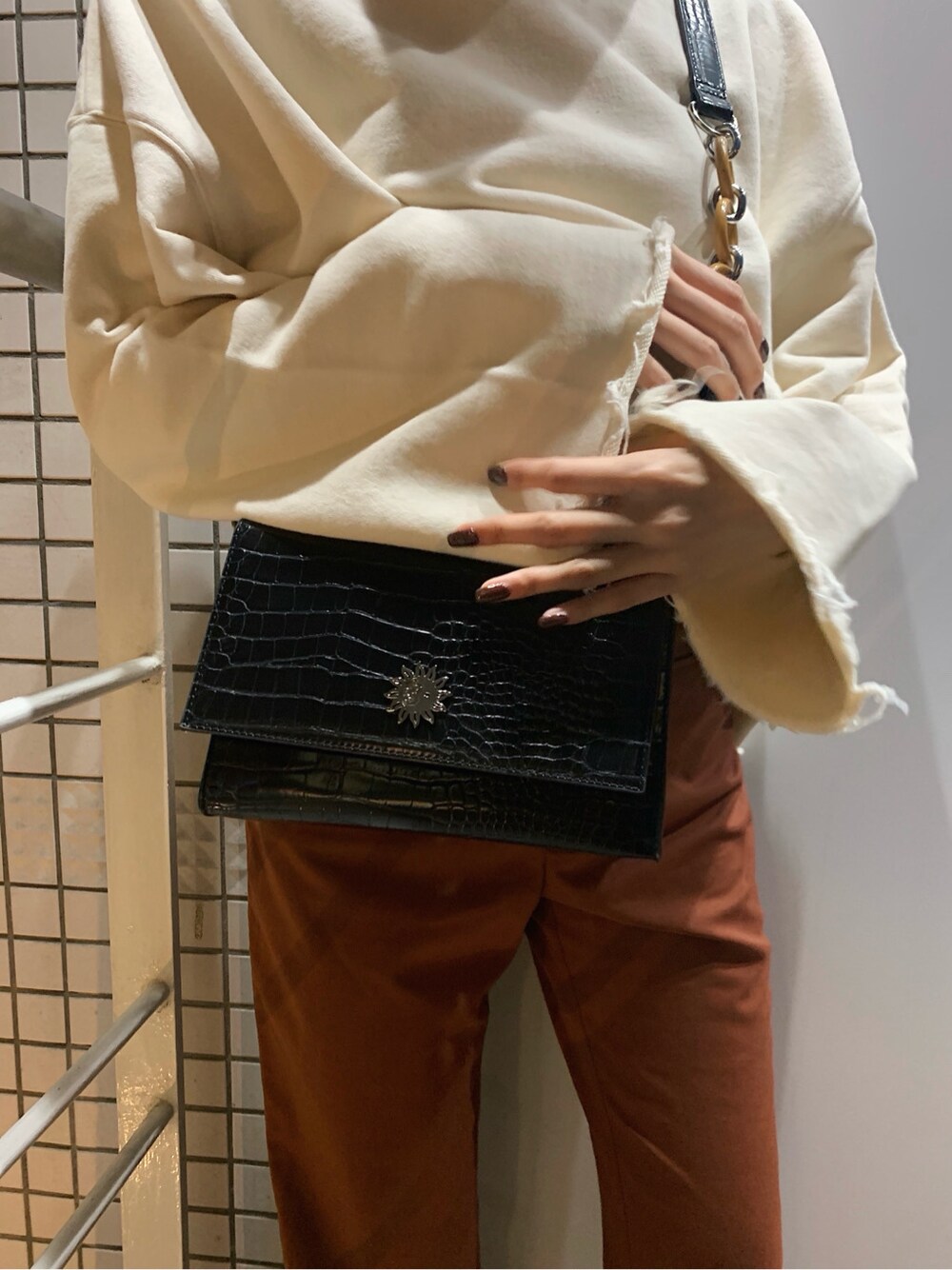 ホワイト系のスウェット、ブラック系のハット、ブラック系のベルトを着用したレディースの春コーディネートの5枚目の写真