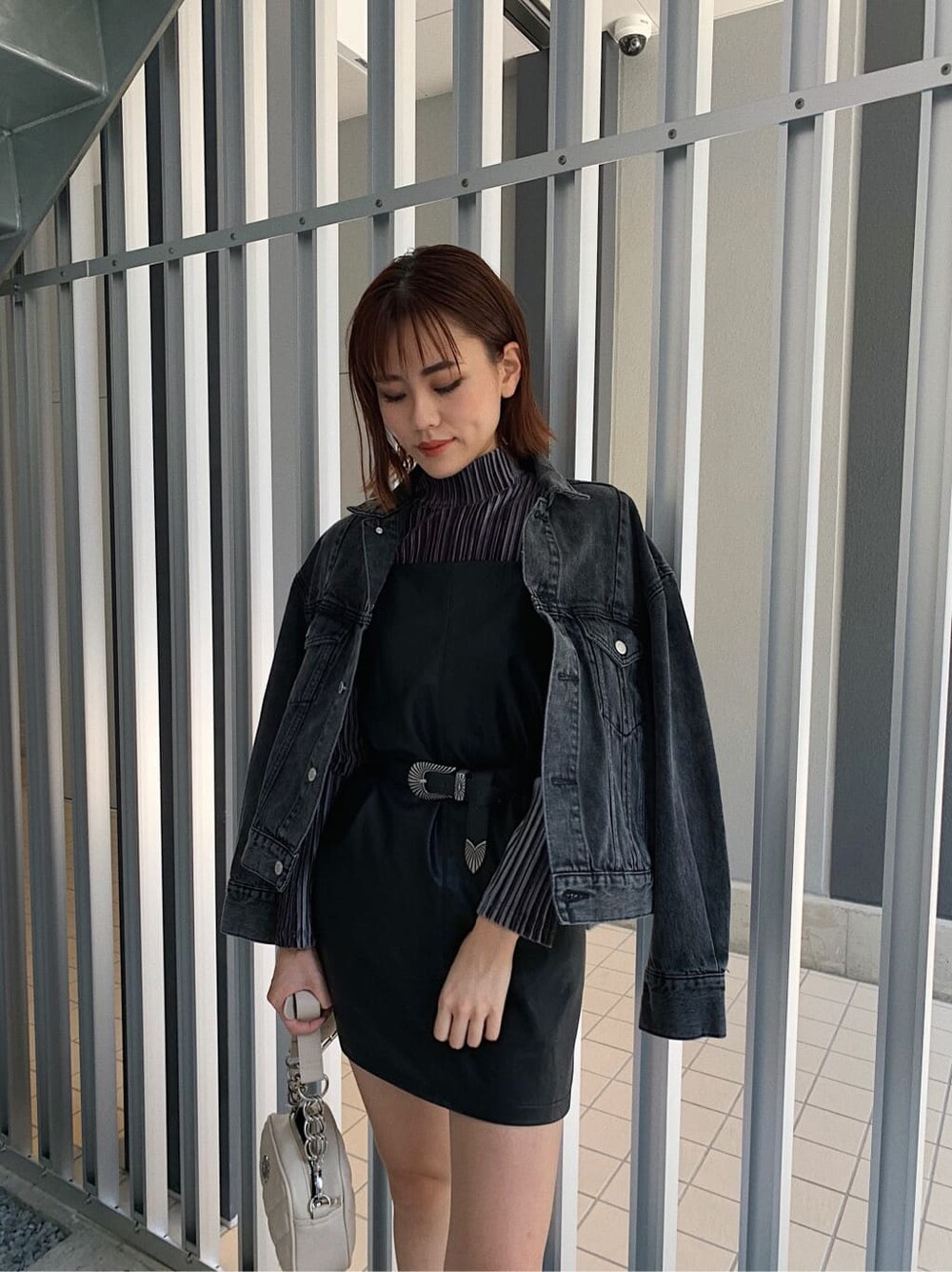 グレー系のTシャツ/カットソー、ブラック系のブーツ、ホワイト系のショルダーバッグを着用したレディースの秋コーディネートの3枚目の写真