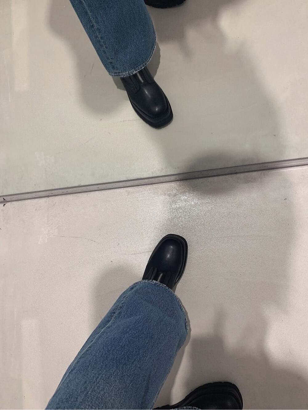 ブラック系のブーツ、ブルー系のデニムパンツ、グリーン系のニット/セーターを着用したレディースの春コーディネートの8枚目の写真