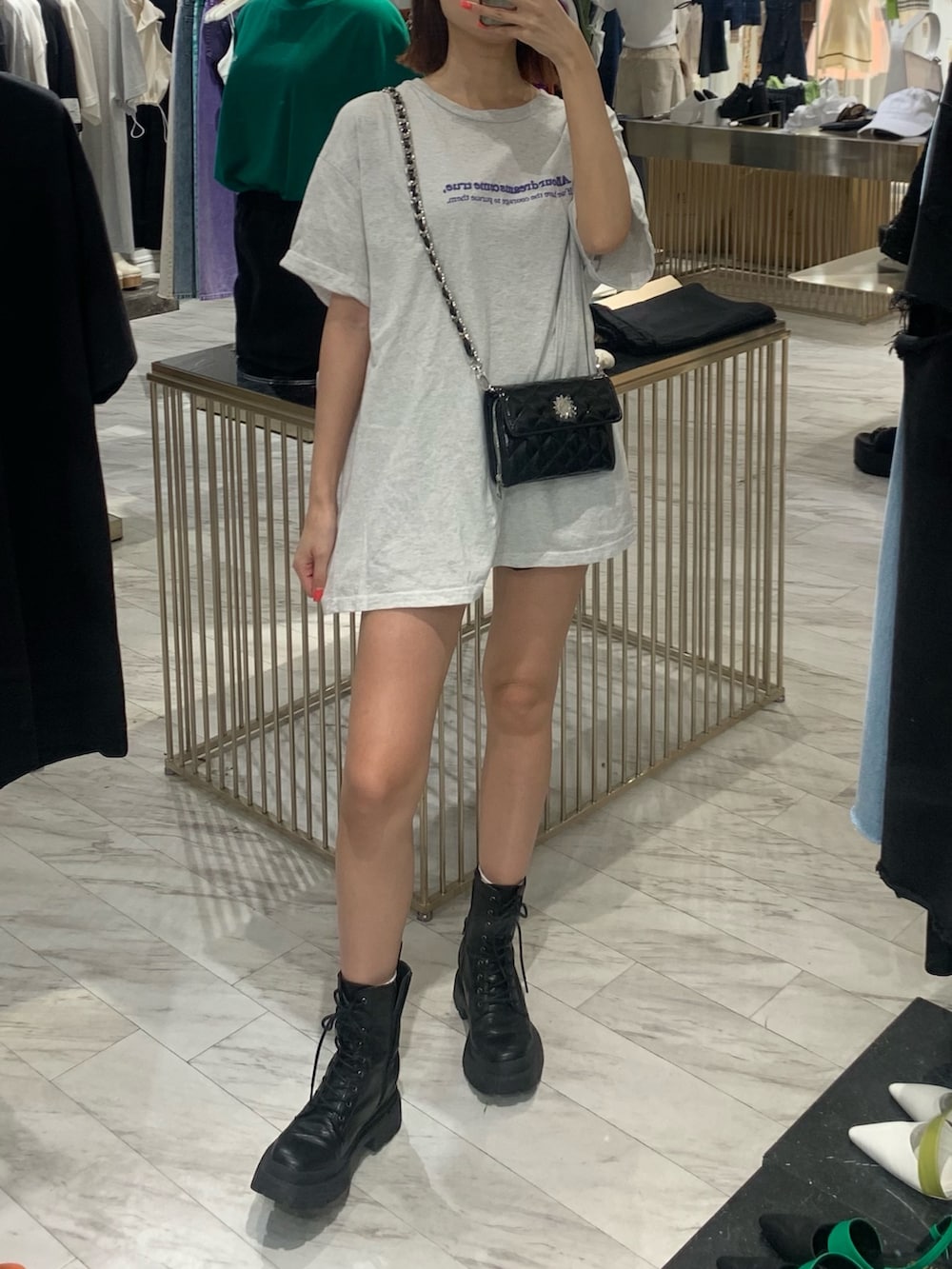 グレー系のTシャツ/カットソー、ブラック系のショルダーバッグ、ブラック系のブーツを着用したレディースの夏コーディネートの2枚目の写真