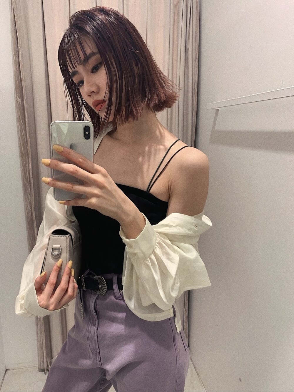 ブラック系のブーツ、ブラック系のキャミソール、パープル系のデニムパンツを着用したレディースの春コーディネートの3枚目の写真