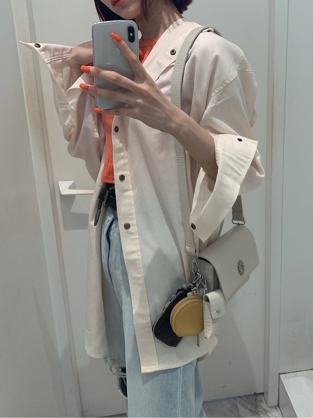 ホワイト系のシャツ/ブラウス、ブラック系のサンダル、ブルー系のデニムパンツを着用したレディースの夏コーディネートの8枚目の写真