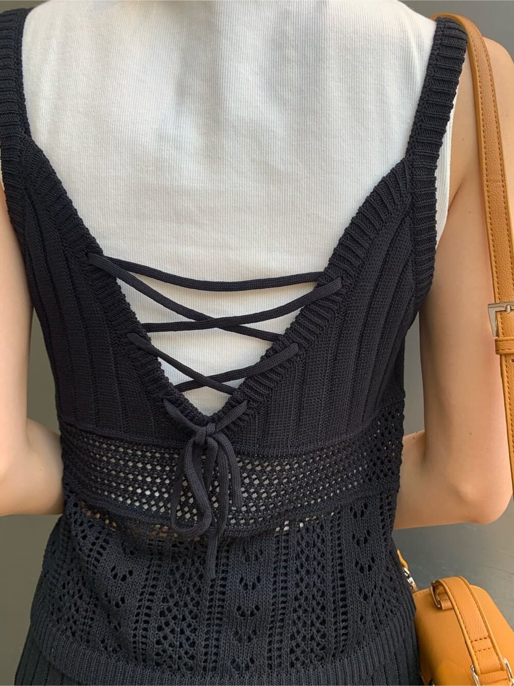 ホワイト系のタンクトップ、ブラック系のキャミソール、ベージュ系のショルダーバッグを着用したレディースの夏コーディネートの7枚目の写真