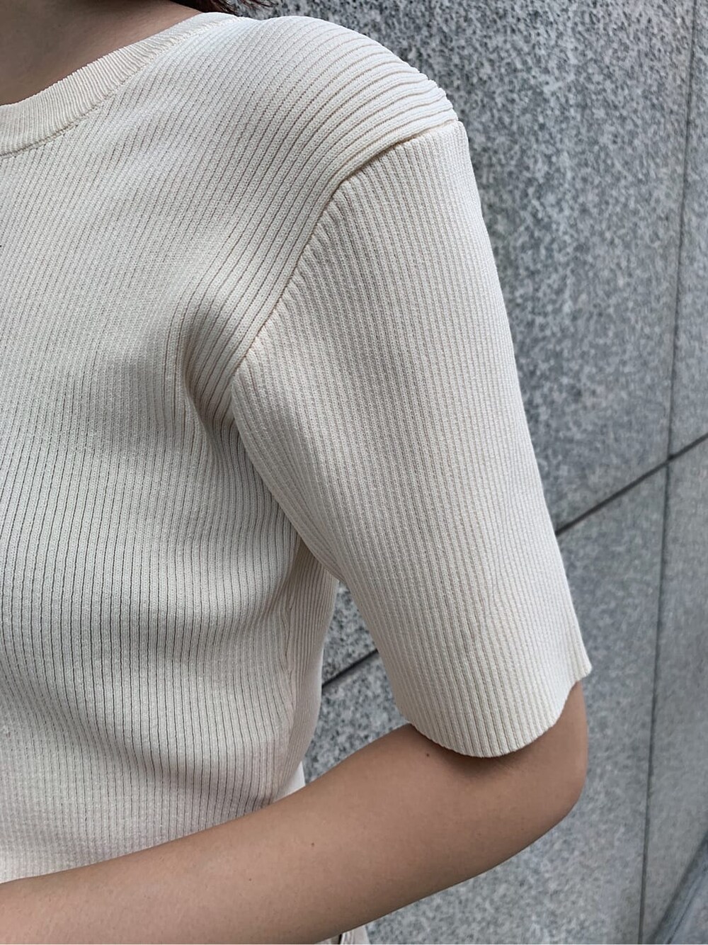 ブラック系のサンダル、ベージュ系のデニムパンツ、ホワイト系のニット/セーターを着用したレディースの夏コーディネートの4枚目の写真