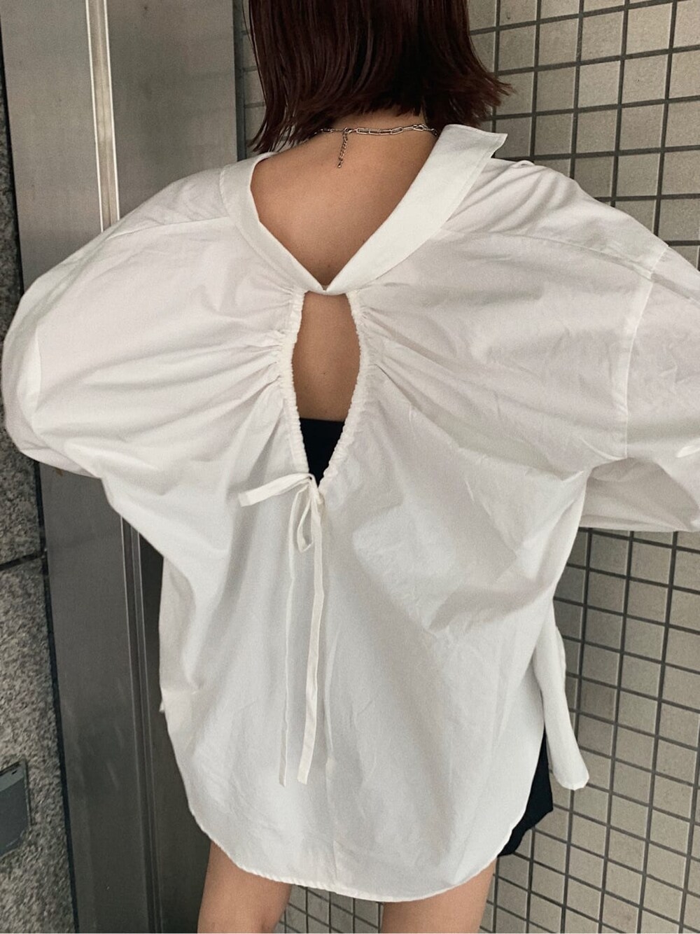 ブラック系のブーツ、ブラック系のスカート、ホワイト系のシャツ/ブラウスを着用したレディースの夏コーディネートの3枚目の写真