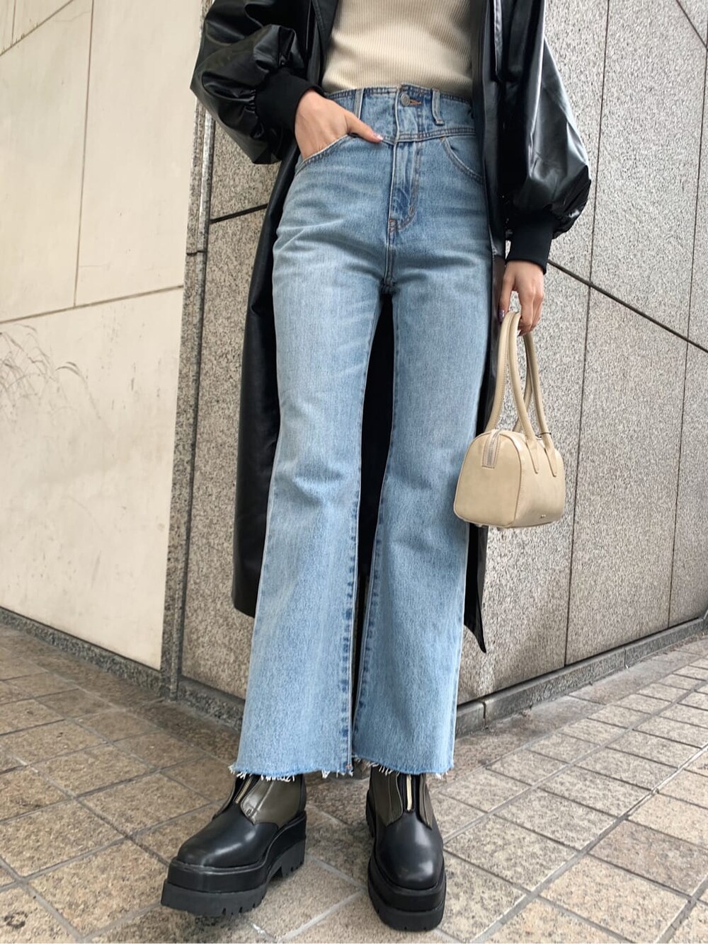 ホワイト系のニット/セーター、ベージュ系のブーツ、ブラック系のトレンチコートを着用したレディースの冬コーディネートの6枚目の写真