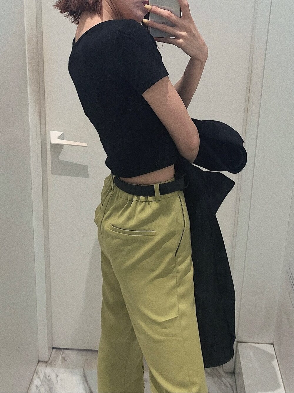 ブラック系のブーツ、ブラック系のブルゾン、グリーン系のその他パンツを着用したレディースの春コーディネートの3枚目の写真