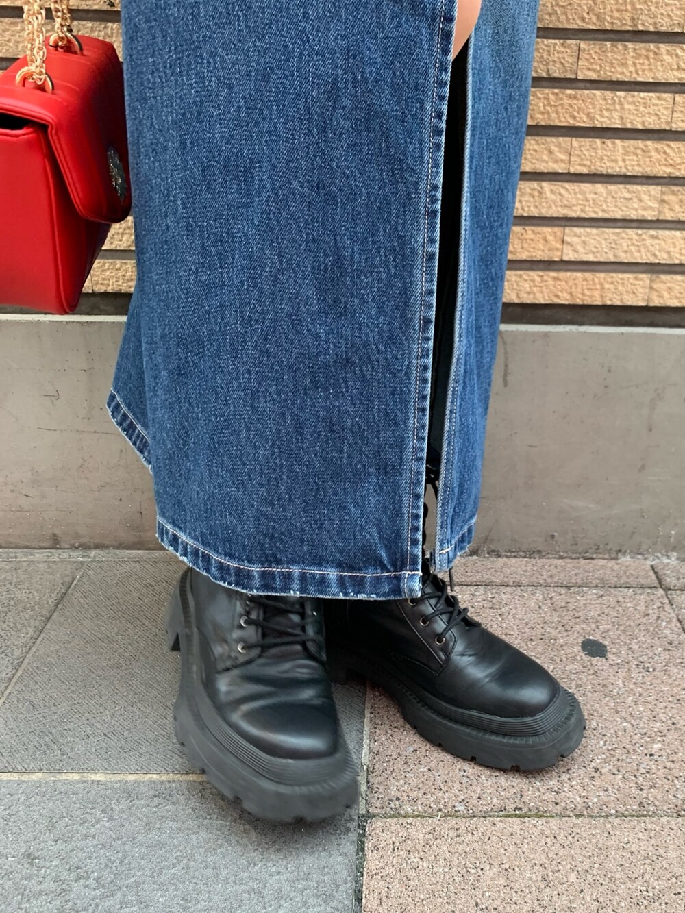 ブルー系のデニムジャケット、ブルー系のデニムスカート、レッド系のショルダーバッグを着用したレディースの秋コーディネートの8枚目の写真