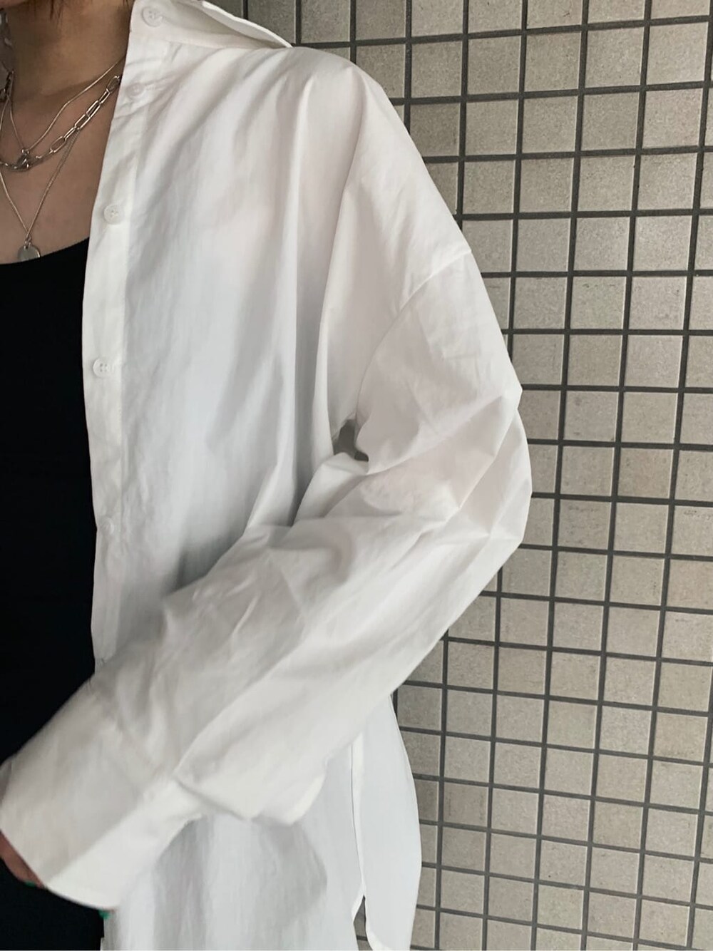 ブラック系のブーツ、ブラック系のスカート、ホワイト系のシャツ/ブラウスを着用したレディースの夏コーディネートの5枚目の写真