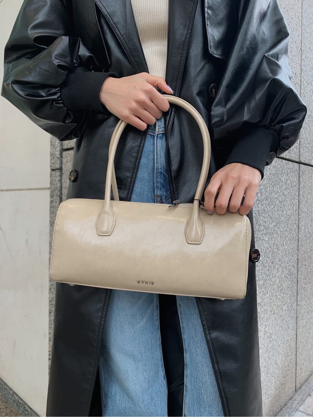 ホワイト系のニット/セーター、ベージュ系のブーツ、ブラック系のトレンチコートを着用したレディースの冬コーディネートの8枚目の写真