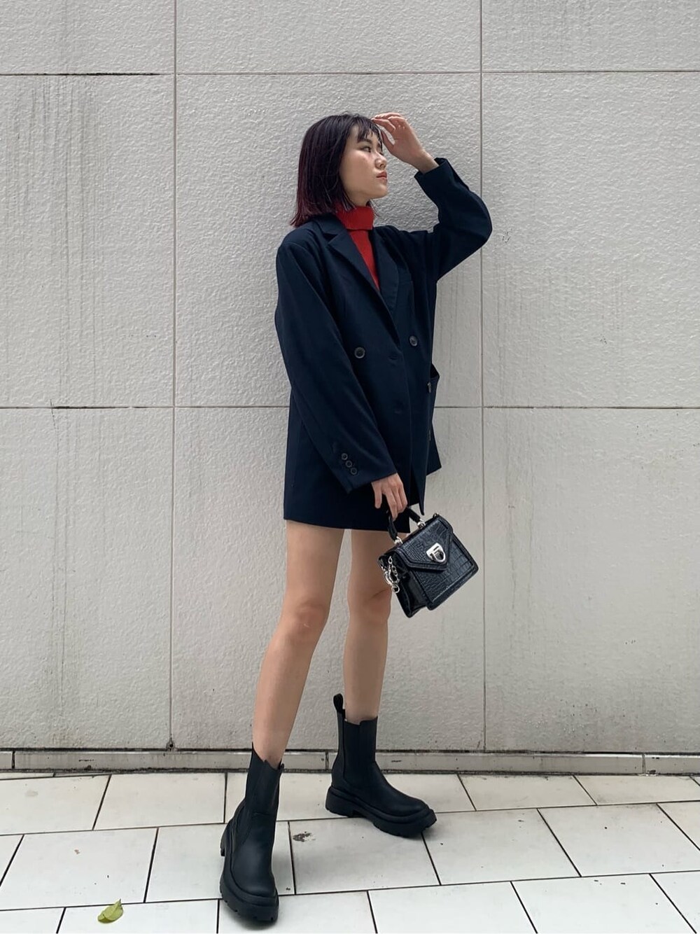 ブルー系のテーラードジャケット、ブラック系のハンドバッグ、ブラック系のブーツを着用したレディースの秋コーディネートの3枚目の写真