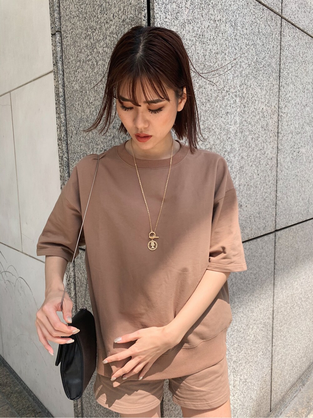 ブラウン系のスウェットを着用したレディースの春コーディネートの3枚目の写真